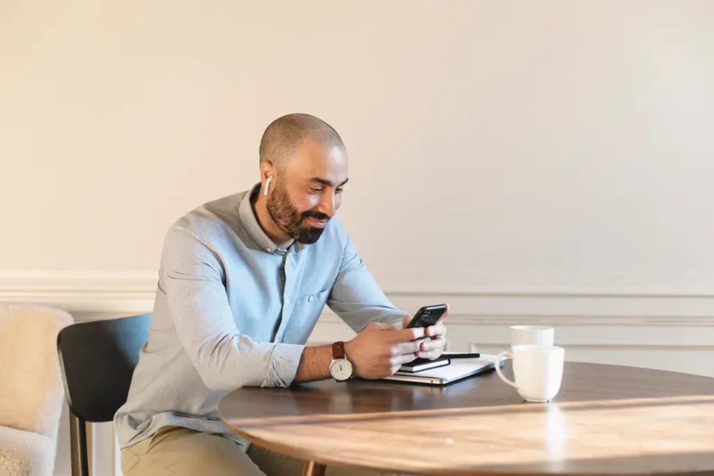 En svensk chef som sitter och arbetar med lönesättning på mobilen, han använder wndys app för att få hjälp med hr-frågor och hr-expertis