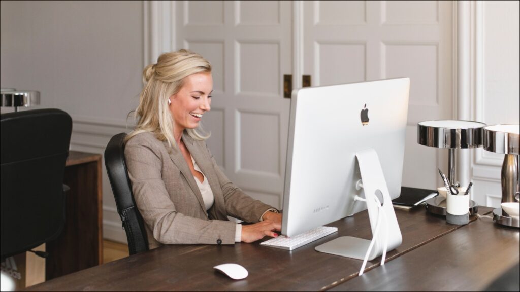 En ung blond kvinna sitter vid sitt skrivbord och deltar i ett webbinarium från Wndy och Fondia