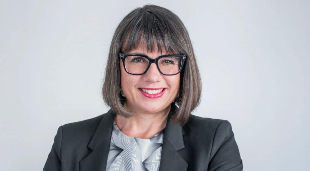 Jenny Hellberg som står med korsade armar och ler