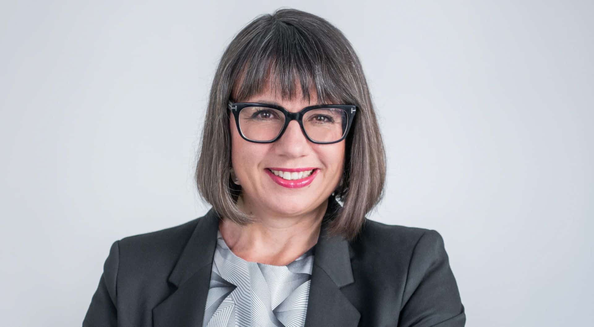 Jenny Hellberg som står med korsade armar och ler